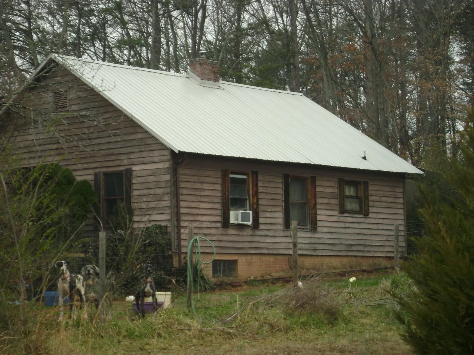 White metal roof on an old wood sided farmhouse, from a Metal Roof Installation job in Ludington